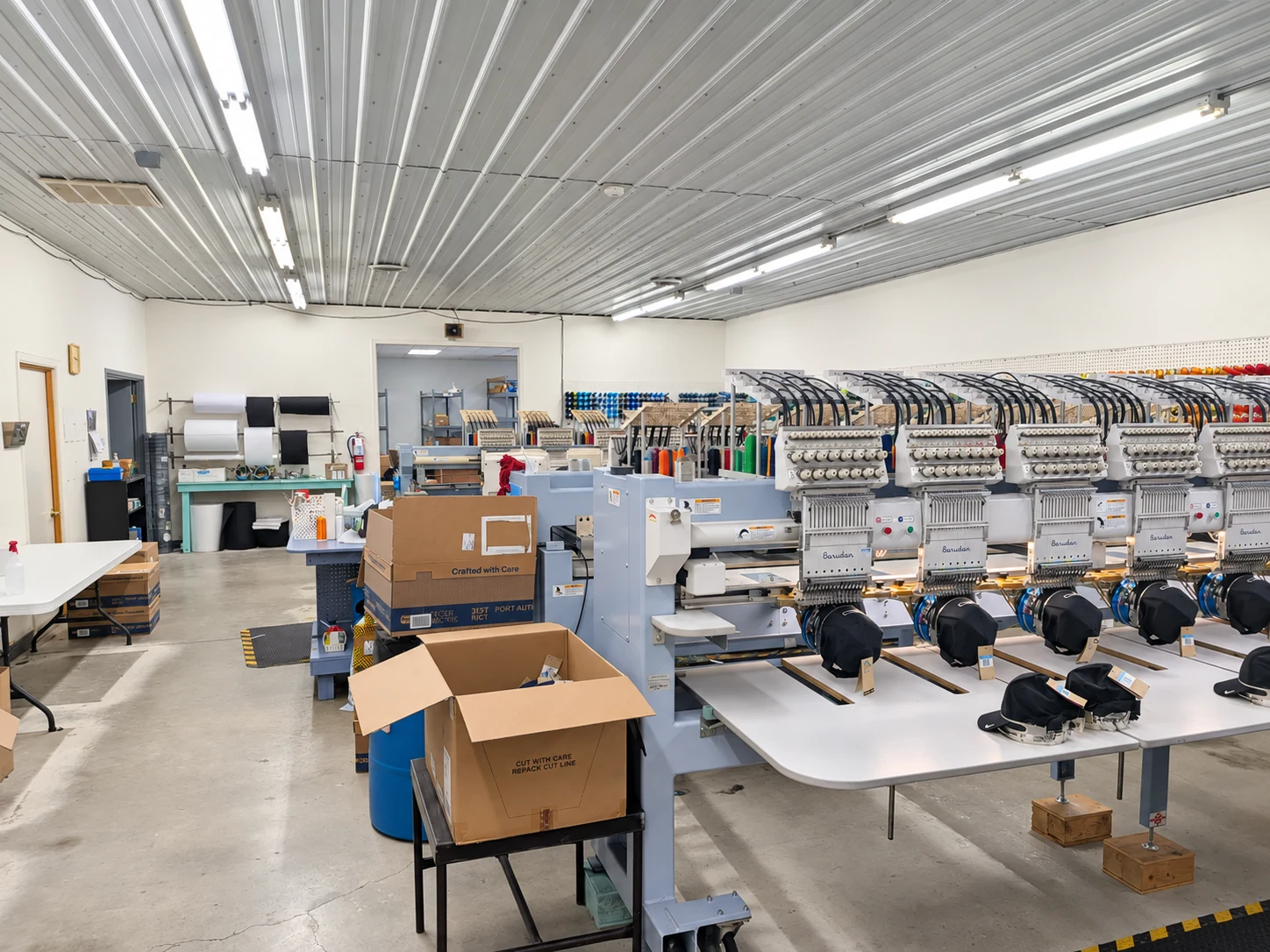 Edited photo: Work tables and embroidery machines inside Del Print’s embroidery department
