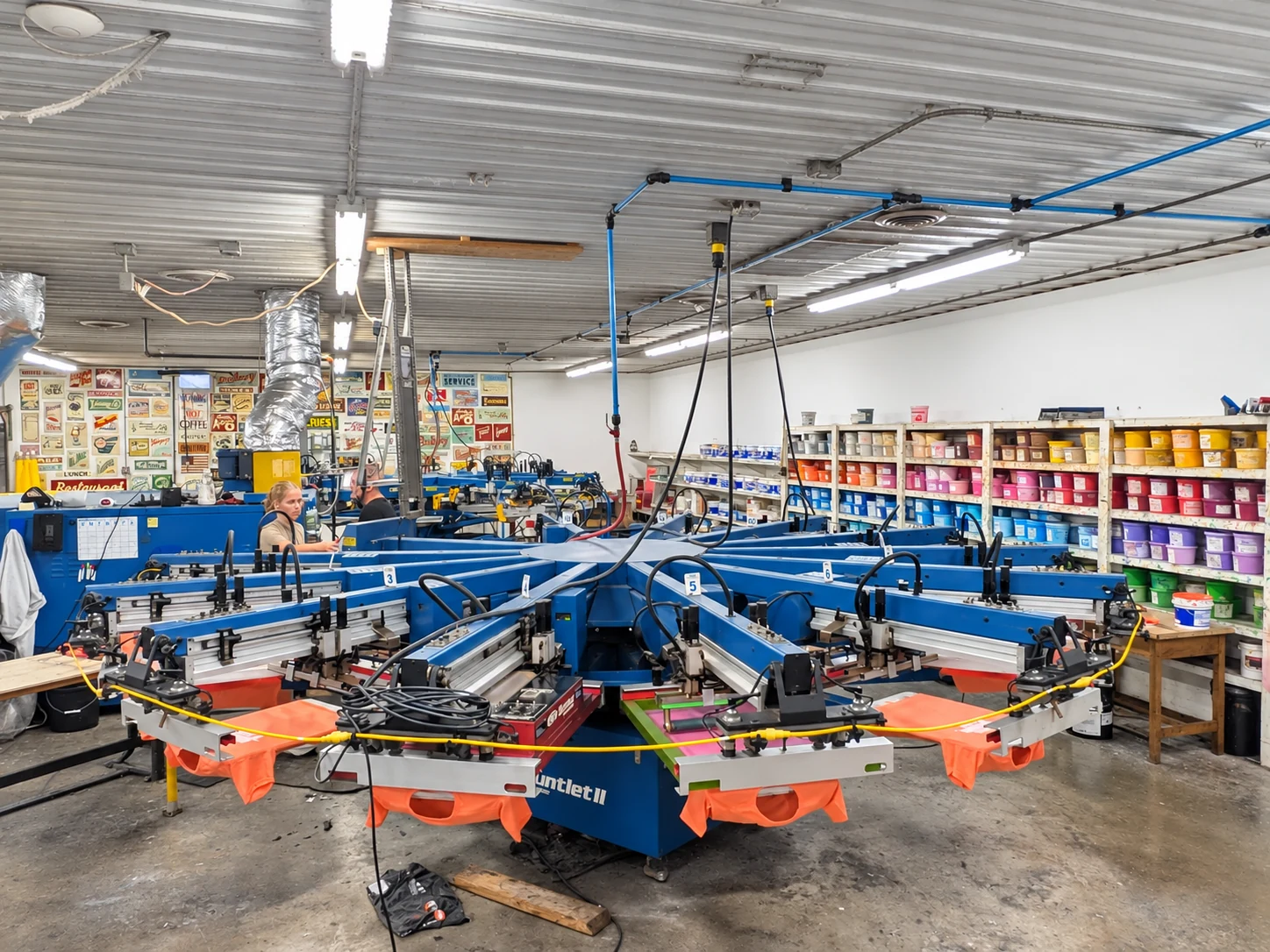 Edited photo: Wide view of Del Print’s screen printing floor and blue printing presses